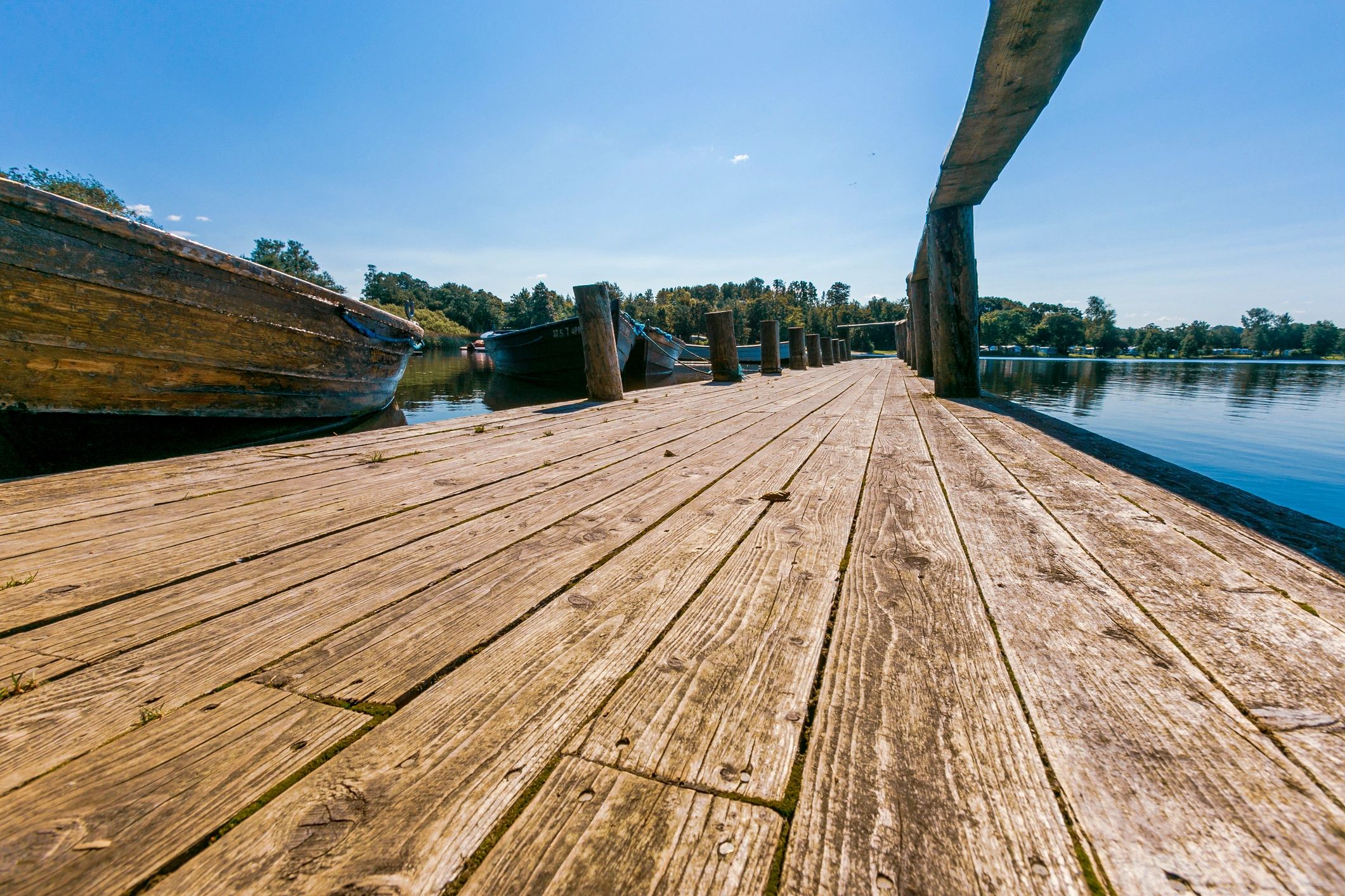 Wooden bridge in a lake with rowing boats moored