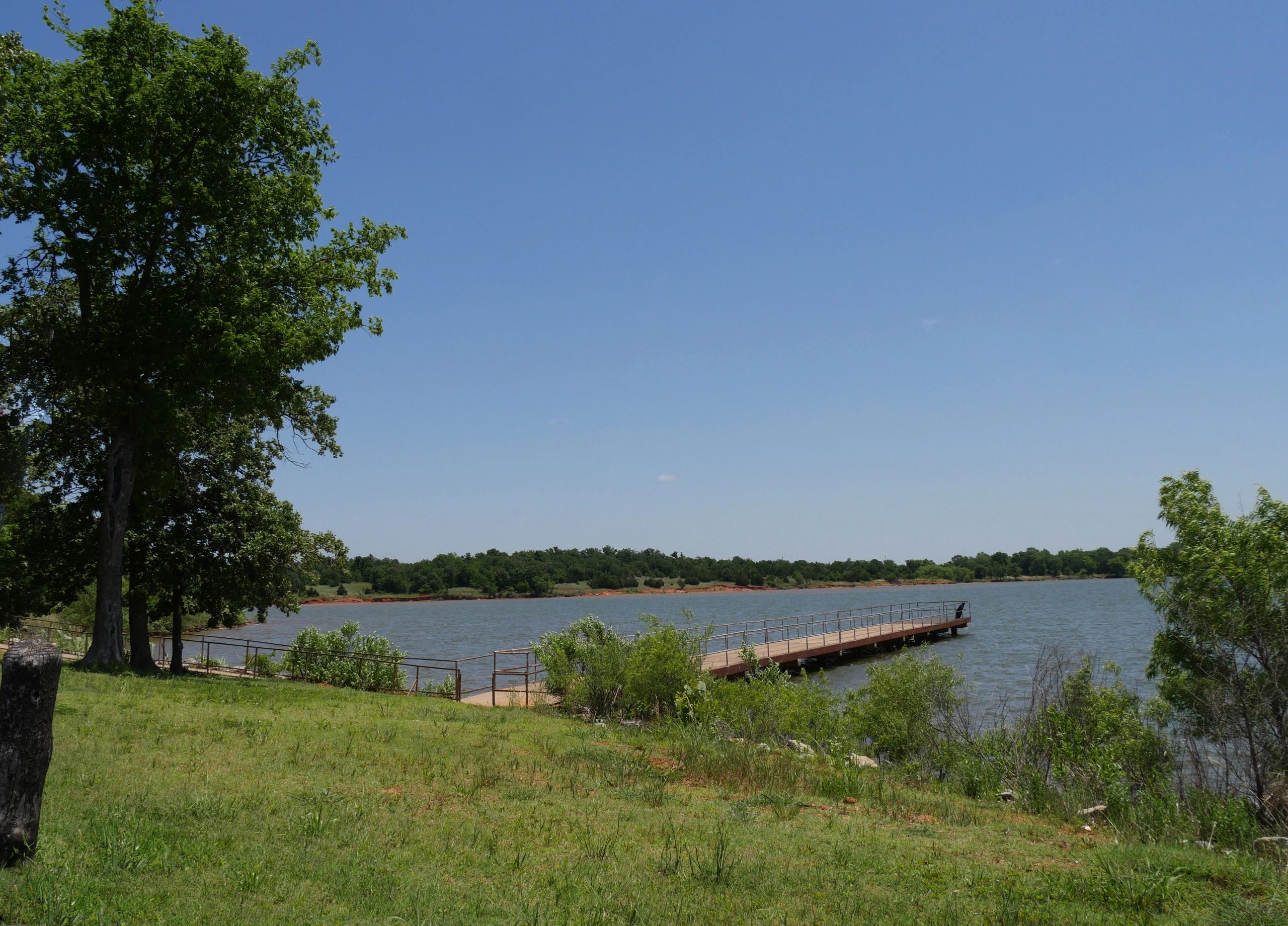 Wide shot of a lakeside with a wooden boat dock